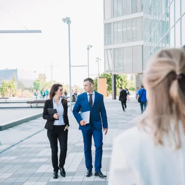 Professional group walking near modern office building representing Australia Skills in Demand Visa 2026 pathway.