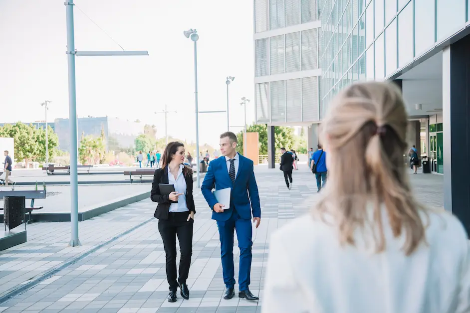 Professional group walking near modern office building representing Australia Skills in Demand Visa 2026 pathway.