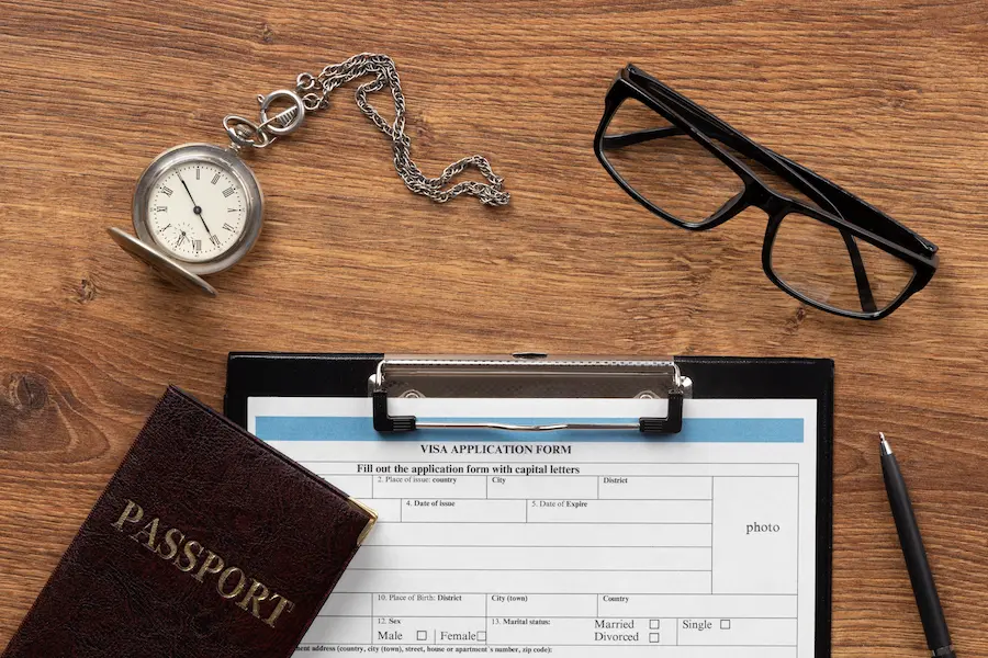 Skilled migration Australia visa documents, passport, application form, and pen on a wooden desk.